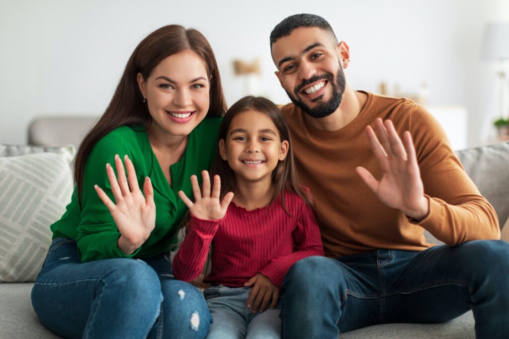 Portrait of happy family waving hands at camera